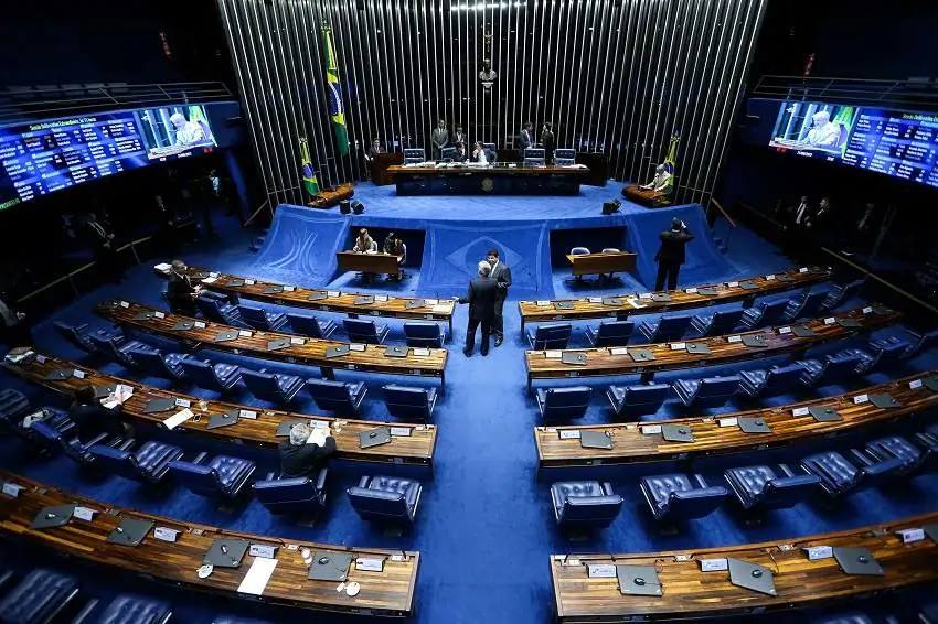 Imagem do senado federal, um salão azul com cadeiras e mesas. Texto: Quanto ganha um senador?