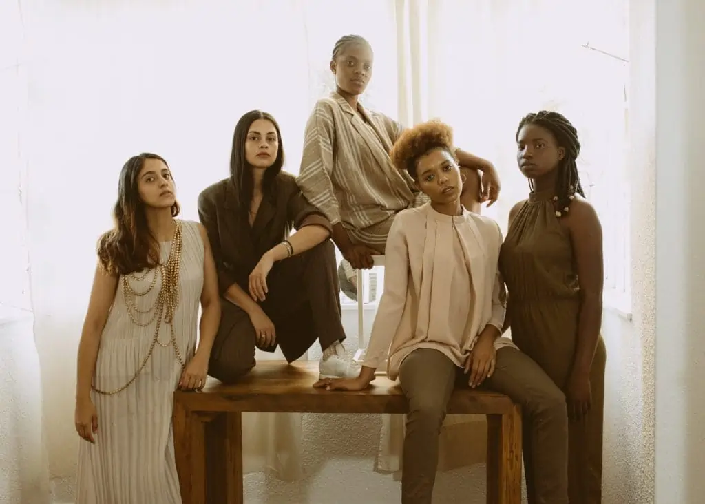 Imagem de 5 mulheres posando para um ensaio fotográfico. Texto: Dia da Mulher: qual a importância do 8 de março?