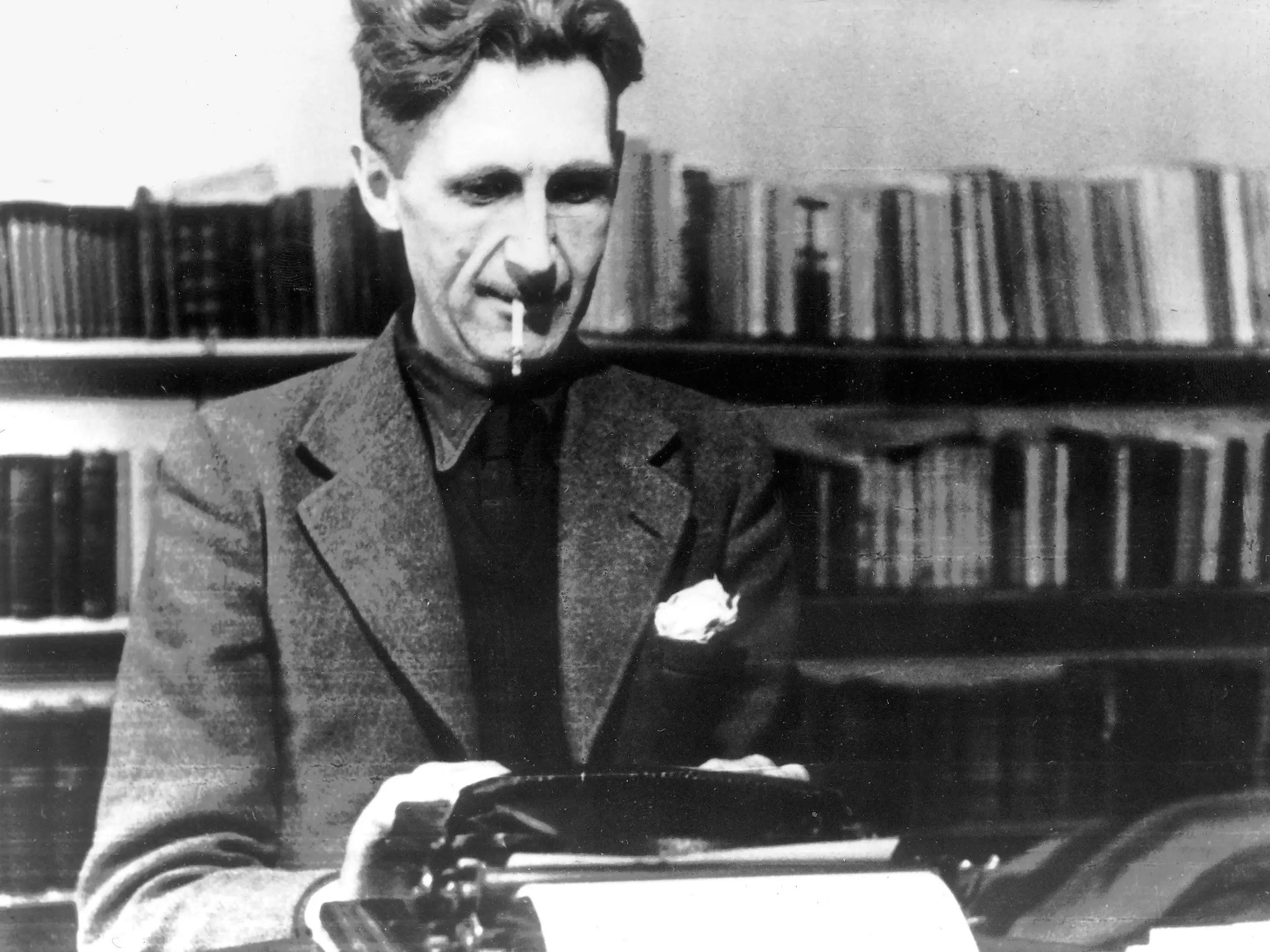 George Orwell na BBCC Homem branco, George Orwell, vestindo um terno, escrevendo em uma máquina de escrever com um cigarro na boca