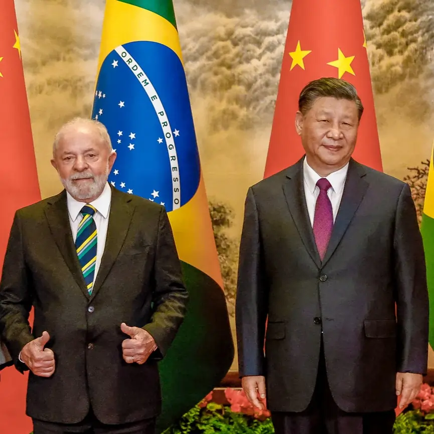 Lula e XI em encontro bilateral, 2023 A imagem apresenta o presidente do Brasil, Lula ao lado do presidente da China, Xi Jinping. Os dois estão lado a lado e na frente das bandeiras de seus respectivos países. Lula aparece com os polegares levantados