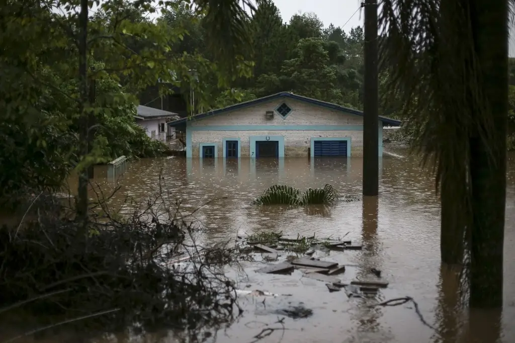 Impacto das chuvas no Rio Grande do Sul. Texto sobre o auxílio reconstrução.