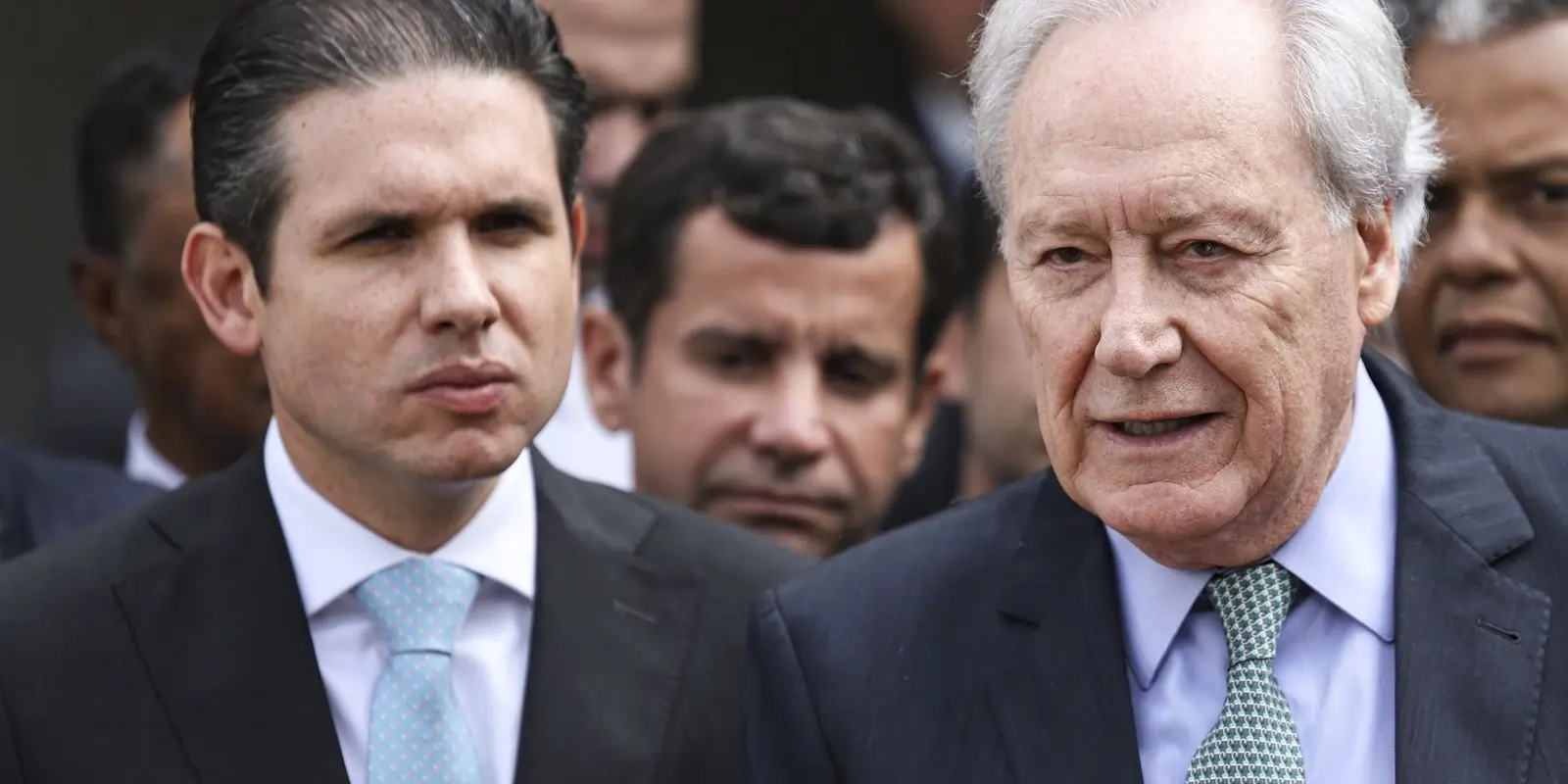 Hugo Motta, semblante sério, usando terno. Ricardo Lewandowski, cabelos brancos, aparenta idade mais avançada, de terno. Texto: Saiba tudo sobre a PEC da segurança.