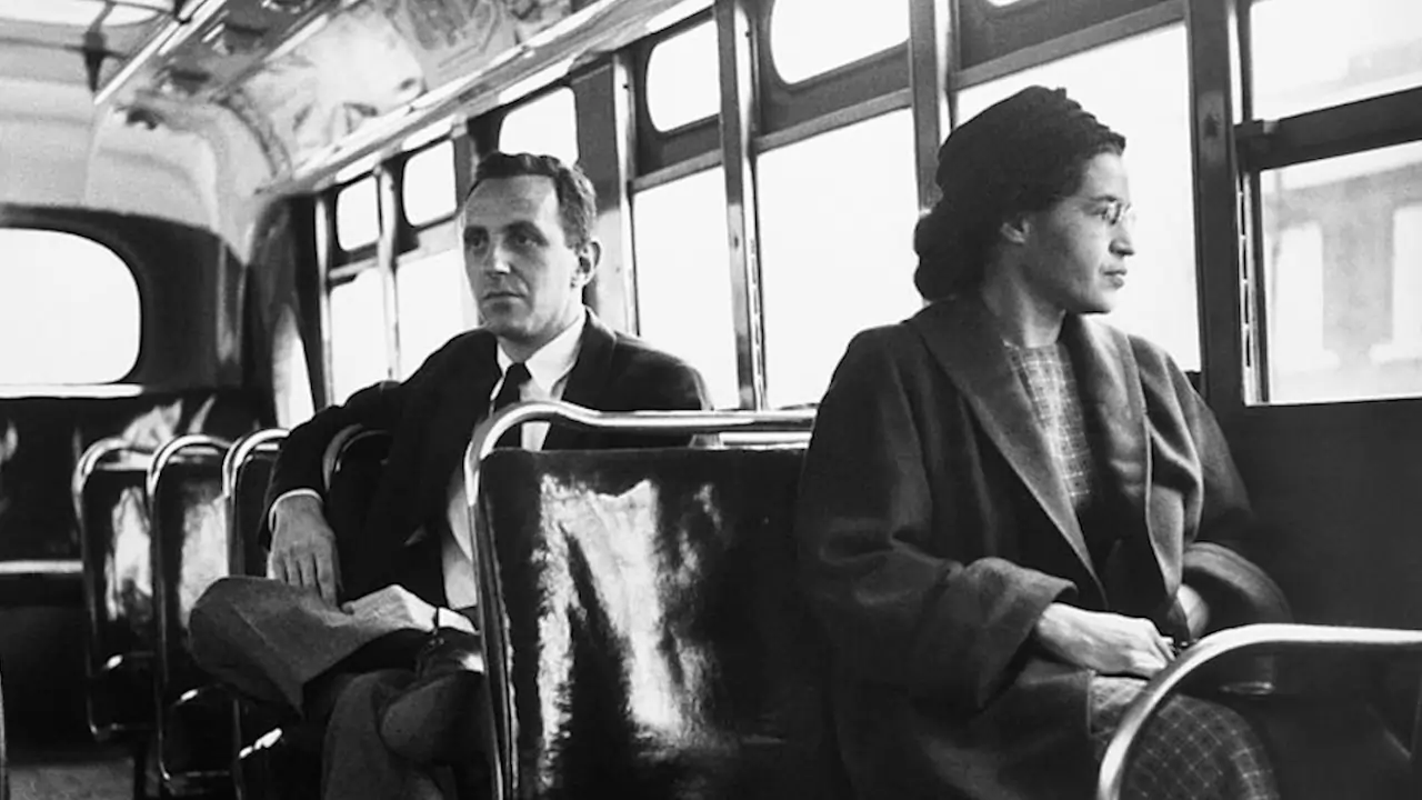 rosa parks, uma mulher negra sentando nas cadeiras da frente de um onibus em Montgomery